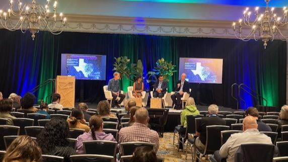 Moderator David Marquis, left, leads a panel at the Hilton Anatole in Dallas at Earth Day 2024.