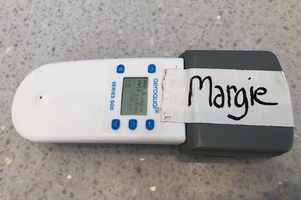 White handheld device with buttons, labeled "Margie" on gray end.