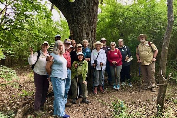 Group of hikers posing together in a lush forest setting.