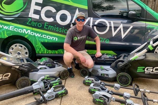 Man kneeling with battery powered tools in front of a van.