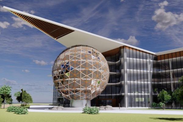 Futuristic building with a geodesic dome and angular roof under a blue sky.