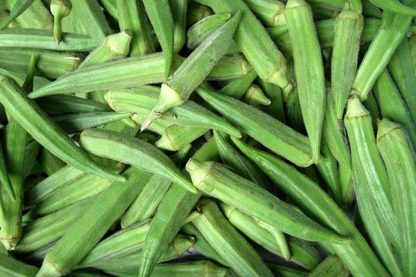Fresh green okra pods piled together.