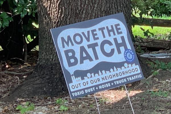 Sign on lawn saying "MOVE THE BATCH" near a tree, with additional text below.