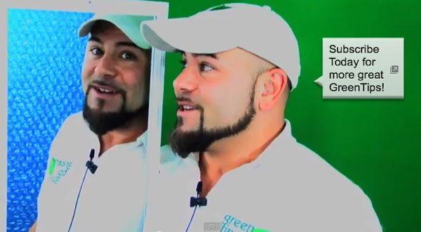 Man in white cap and polo shirt smiling, with reflection in a mirror.