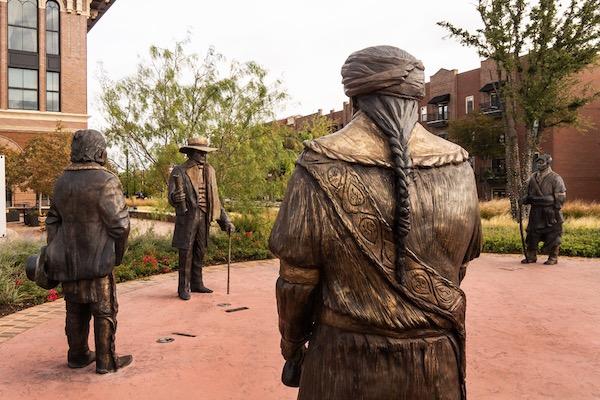 Bronze statues of historical figures in a courtyard setting.