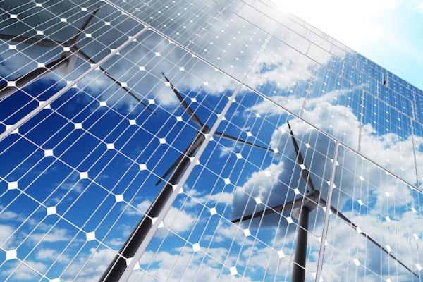 Solar panels reflecting wind turbines and clouds.