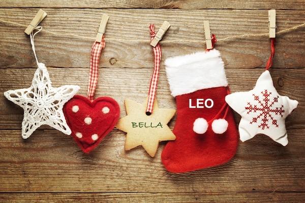 Star, heart, star, stocking, and snowflake hang on a wooden background.