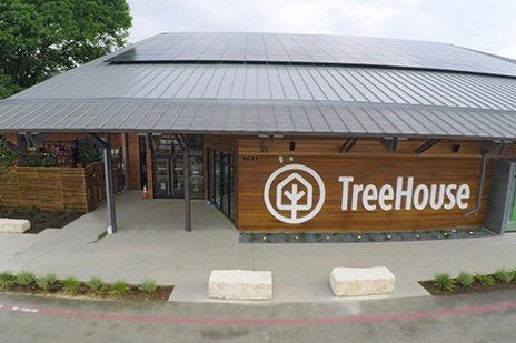 Eco-friendly store with solar panels, TreeHouse logo on wooden facade.