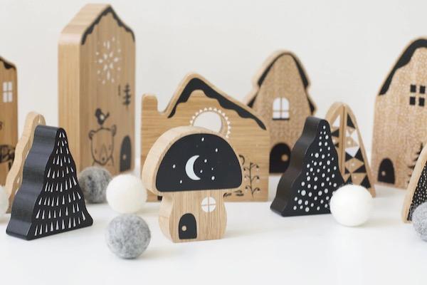 Wooden toy village with trees, houses, and a mushroom under a night sky theme.